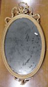 Oval gilt-framed mirror with scroll and floral decoration, 68cm