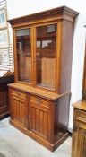 Late Victorian walnut bookcase with glazed double doors above two panelled frieze drawers and two