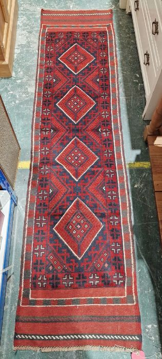 Meshwani red ground wool runner with one row of four diamond medallions and multiple geometric