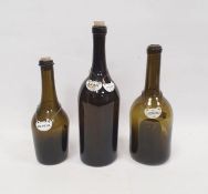 Three green glass wine bottles with enamelled labels, two with kick-in bases, with enamelled