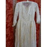 A 1950's figured satin wedding dress, some staining and damage to the train with an embroidered,
