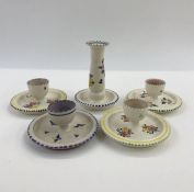 Poole pottery candlestick holder, no.168 to base and four various eggcups, one painted purple and