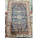 Eastern style blue ground rug with central herati enclosed by geometric pattern, multiple