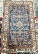 Eastern style blue ground rug with central herati enclosed by geometric pattern, multiple