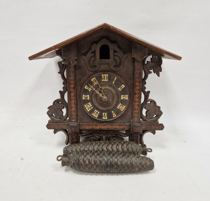 Black Forest style carved and pierced cuckoo clock decorated with leaves with typical pinecone