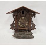 Black Forest style carved and pierced cuckoo clock decorated with leaves with typical pinecone