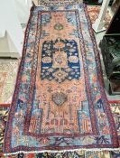Large red ground rug with central navy geometric medallion enclosed by geometric shapes and stylised
