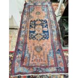 Large red ground rug with central navy geometric medallion enclosed by geometric shapes and stylised