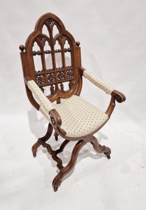 Victorian carved oak Gothic X-frame chair, the pointed arched back fretwork carved with trefoil