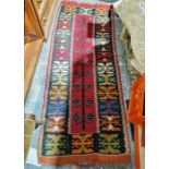Eastern red ground kilim runner with central stylised plant, single geometric border 205cm X 82cm