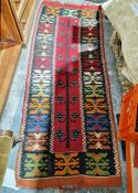 Eastern red ground kilim runner with central stylised plant, single geometric border 205cm X 82cm