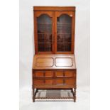 Oak bureau bookcase with glazed double doors above panelled fall front, revealing two drawers and