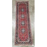 Central Persian red ground Kashan runner with four floral medallions on a herati field, multiple