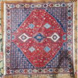 Eastern red ground rug with three hooked lozenge medallions on a floral field, multiple floral
