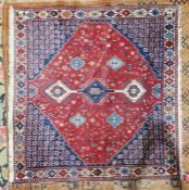 Eastern red ground rug with three hooked lozenge medallions on a floral field, multiple floral