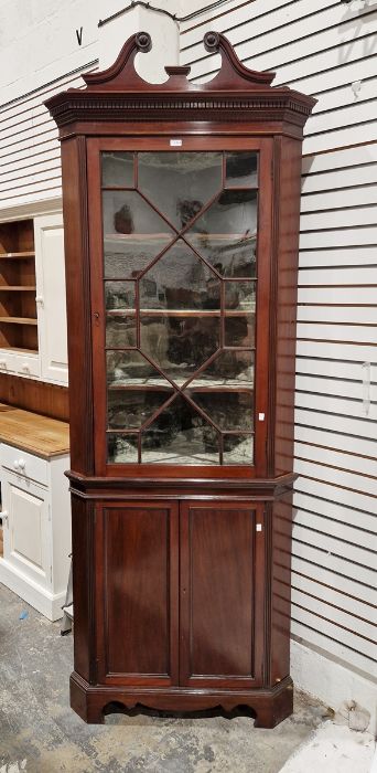 Edwardian mahogany corner cupboard with swan neck above astragal-glazed cupboard, on panel