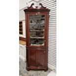 Edwardian mahogany corner cupboard with swan neck above astragal-glazed cupboard, on panel