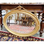 Gilt oval wall mirror with bevelled edge, 86cm wide