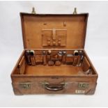 Large leather suitcase with part fitted interior of bottles, brushes, mirrors, etc, with name plaque