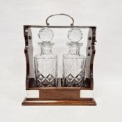 Polished wood and cut glass two bottle tantalus, silver plate mounts, 32cm high Condition
