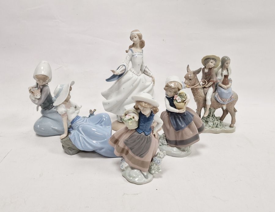 Five Lladro figures including a boy and girl riding a donkey, a pair of girls with baskets of