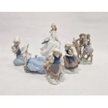 Five Lladro figures including a boy and girl riding a donkey, a pair of girls with baskets of