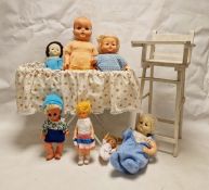 A doll's white painted metal cot with flounce, six various sized celluloid dolls and a doll's