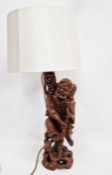 Chinese carved hardwood figural lamp base, 20th century, formed as a man holding on staff, on
