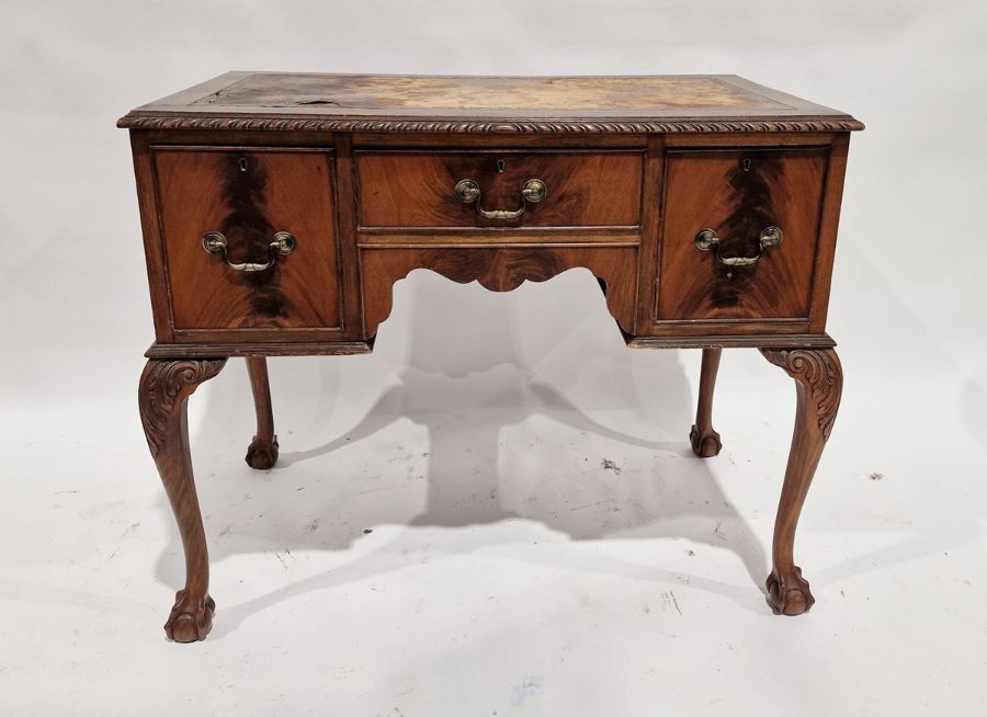 20th century mahogany kneehole desk with brown leather insert, on cabriole supports and claw and