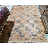 Large Eastern red ground rug with three rows of five elephant foot guls, single geometric border