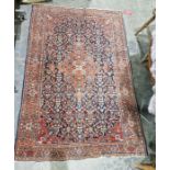 Eastern style red ground rug with central floral medallion on floral trelliswork field, herati