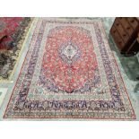 Central Persian Kashan red ground carpet with central floral medallion enclosed by floral pattern,