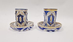 Pair of Bohemian overlay blue and gilt glass beakers on stands, with Arabic script Condition