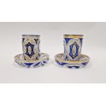 Pair of Bohemian overlay blue and gilt glass beakers on stands, with Arabic script Condition