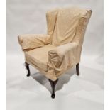 Yellow upholstered wing armchair on mahogany cabriole supports