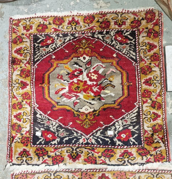 Pair of Eastern style red ground rugs with central floral medallion, floral border, one worn 67cm - Image 2 of 2