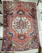 Eastern style red ground rug with central floral medallion on a floral field, multiple geometric and