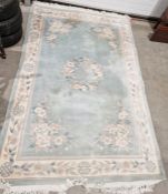 Large Chinese celadon green ground superwash rug with central floral medallion, floral border