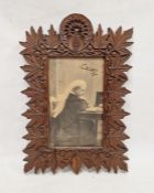 Photograph of Queen Victoria wearing a white veil and seated at a desk, with facsimile signature and