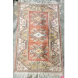 Modern red ground wool pile rug with three floral medallions to floral border 132cm x 84cm