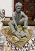 Resin model of a boy sitting on a rock reading a book, 110cm high x 119cm wide approx.