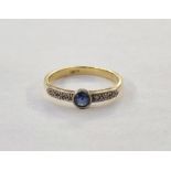 18ct gold, sapphire and diamond ring, the circular collet set sapphire flanked by small diamonds