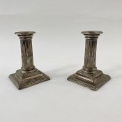 Pair of Victorian silver dwarf candlesticks, each with stop-fluted column, on square stepped