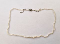 Graduated seed pearl necklace on silver-coloured metal clasp set with gemstones