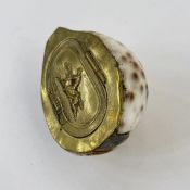 Snuff box created from a cowrie shell, with brass-coloured lid decorated with picture of a