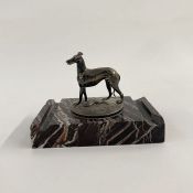 Silver model of a greyhound with hare underfoot, on circular engraved base, mounted on a rectangular
