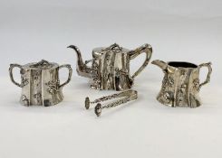 An early 20th century Chinese silver three piece tea service, tree bark decorated with relief