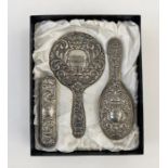 1950's silver three-piece dressing set, repousse decorated, Birmingham 1959, makers B. & Co., in