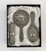 1950's silver three-piece dressing set, repousse decorated, Birmingham 1959, makers B. & Co., in