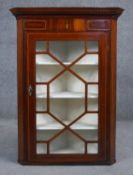 A 19th century mahogany corner cabinet with satinwood and ebony inlaid frieze and astragal glazed